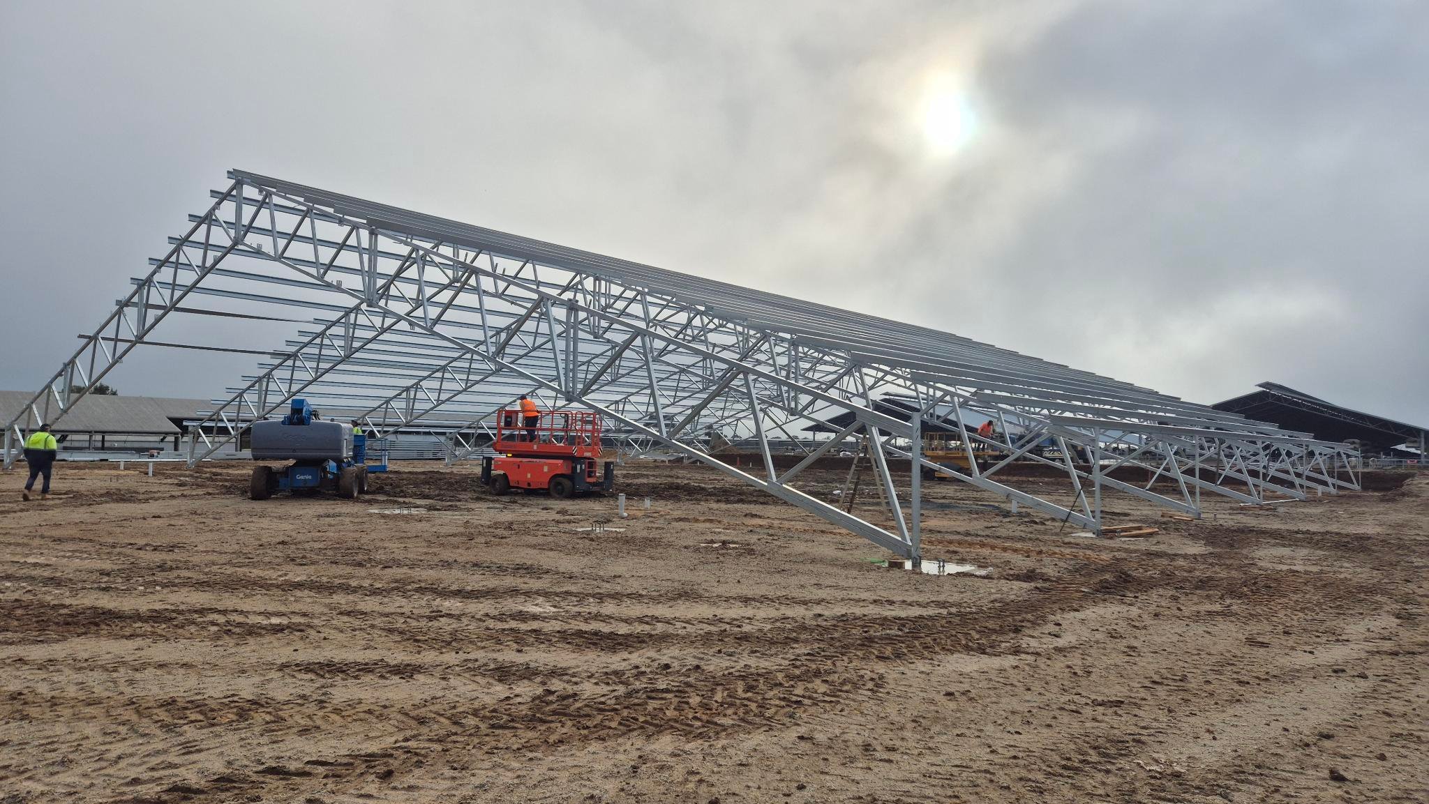 The galvanised steel roof of a dairy building ready to be assembled