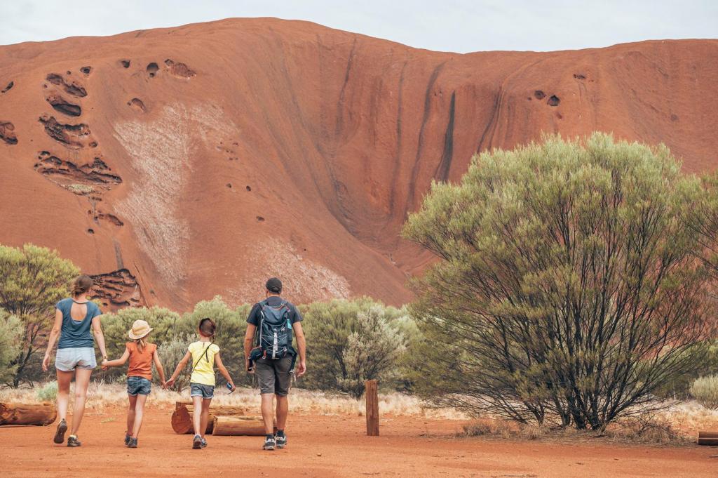 family walking in front of Uluru 