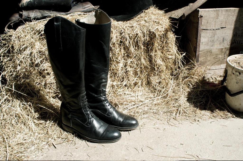 riding boots near hay bale 