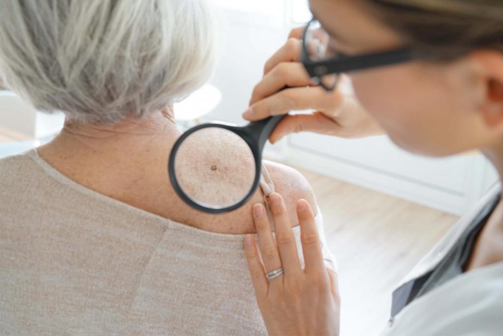 doctor checking senior woman for skin cancer 