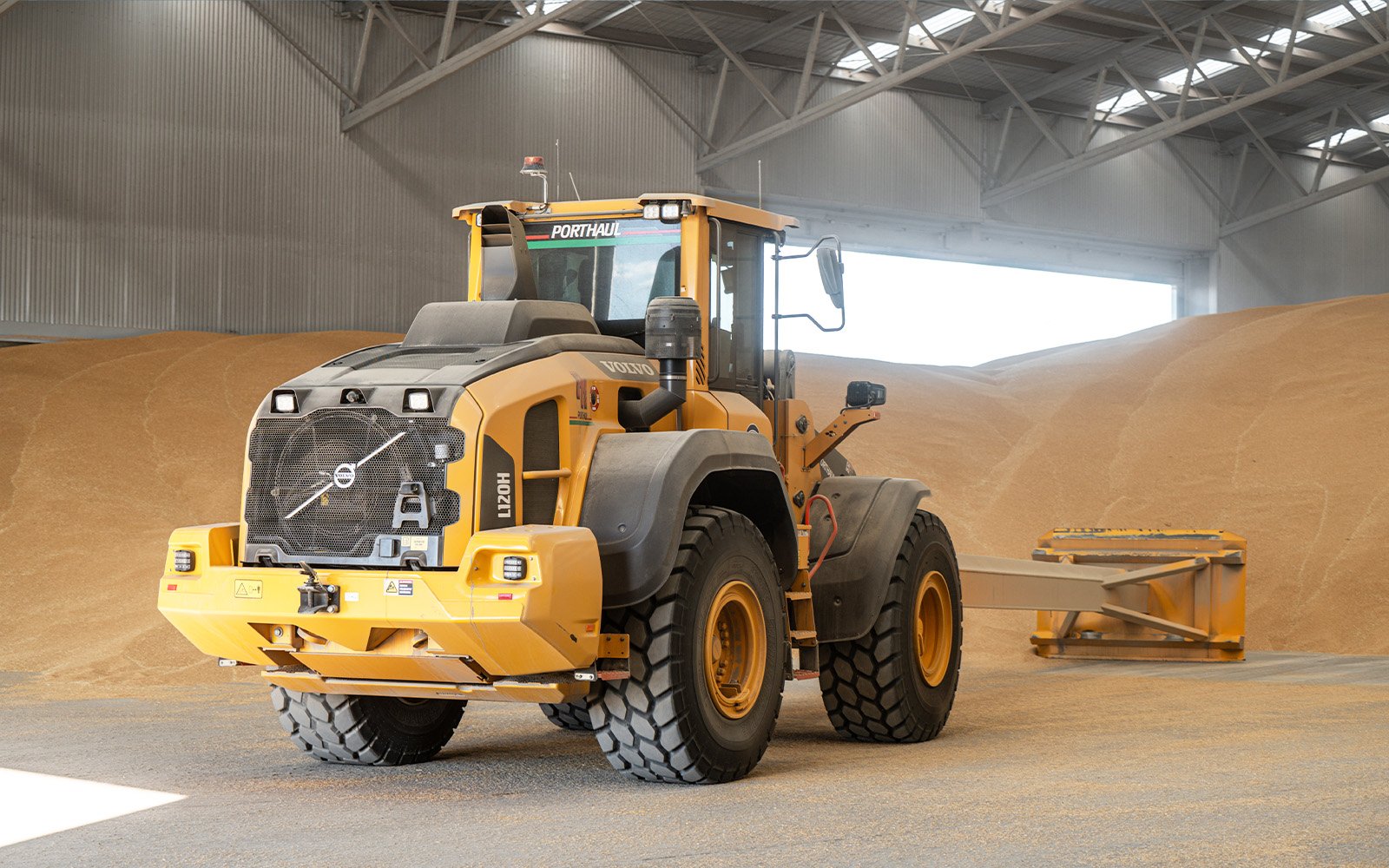Porthaul truck unloading grain inside the large-capacity steel storage shed constructed by Central Steel Build, demonstrating efficient agricultural logistics.