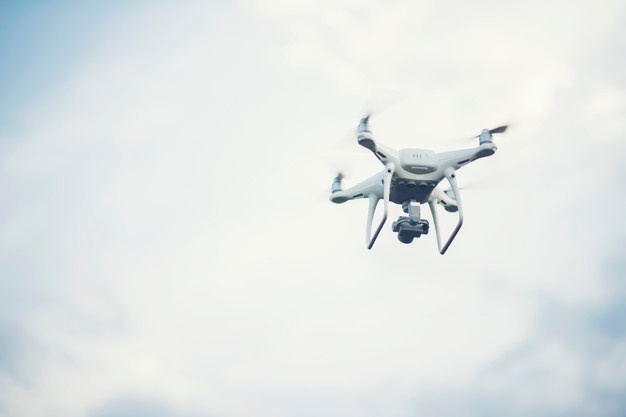 Flying drone up to blue sky background Free Photo