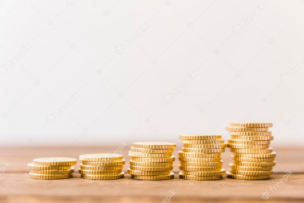 Increasing stacked coins on wooden desk Free Photo